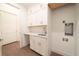 Bright laundry room featuring white cabinets, quartz counters, and a stainless steel sink at 159 Colony Point Dr, Punta Gorda, FL 33950