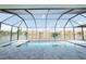 Beautiful pool inside a screened lanai overlooking a lake with palm trees at 159 Colony Point Dr, Punta Gorda, FL 33950