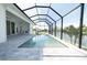 Beautiful pool inside a screened lanai with views of the lake and palm trees at 159 Colony Point Dr, Punta Gorda, FL 33950