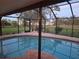 Relaxing kidney-shaped pool, screened enclosure, and lush green backyard at 195 Sylvania, Englewood, FL 34223