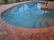 Inviting kidney-shaped pool with brick coping and a view of the trees at 195 Sylvania, Englewood, FL 34223