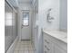 Clean bathroom with shower and tub combination, white vanity, closet and access to the backyard at 1954 Arkansas Ave, Englewood, FL 34224