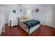 The bedroom has hardwood floors, a bed with an afghan, and artwork and white furnishings at 1954 Arkansas Ave, Englewood, FL 34224