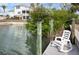 Relaxing waterfront view from the private dock with a rocking chair and lush foliage at 1954 Arkansas Ave, Englewood, FL 34224
