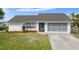 Charming single-story home featuring well-manicured lawn, garden beds and a screened two-car garage at 1954 Arkansas Ave, Englewood, FL 34224