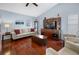 Well-lit living room features hardwood floors, a sofa, seating, and an entertainment center at 1954 Arkansas Ave, Englewood, FL 34224