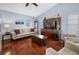 Comfortable living room featuring vaulted ceilings, a large entertainment center, comfortable seating, and wood flooring at 1954 Arkansas Ave, Englewood, FL 34224