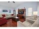 A cozy living room with high ceilings, a sofa, two chairs, and an entertainment center at 1954 Arkansas Ave, Englewood, FL 34224