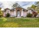 Pink one-story house with a white door, landscaping, and a green lawn at 5401 Kaspar St, Port Charlotte, FL 33981