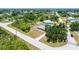 An aerial view of a light gray home with a lush green yard, surrounded by trees and neighborhood streets at 7330 Regina Dr, Englewood, FL 34224