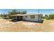 Backyard view of the home with a screened-in porch and ample yard space at 7330 Regina Dr, Englewood, FL 34224