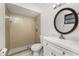Bathroom with tiled shower, modern vanity, and round mirror at 7330 Regina Dr, Englewood, FL 34224