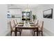 Bright dining room with white cabinetry and stylish table set for a meal, complemented by backyard views at 7330 Regina Dr, Englewood, FL 34224