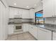 Well-equipped kitchen showcasing white cabinets, granite countertops, and stainless steel appliances at 7330 Regina Dr, Englewood, FL 34224