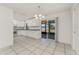 Bright kitchen and dining area featuring white cabinetry, granite countertops, and tile flooring at 7330 Regina Dr, Englewood, FL 34224