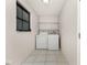 Functional laundry room featuring a washer, dryer, and wire shelving for storage at 7330 Regina Dr, Englewood, FL 34224
