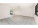 Open living area features tile flooring, a ceiling fan, and sliding glass doors to the outdoors at 7330 Regina Dr, Englewood, FL 34224