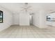 Open-concept living room with neutral tones, tile flooring, and ample natural light at 7330 Regina Dr, Englewood, FL 34224