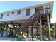 Elevated coastal home with storm shutters and wooden deck, offering serene views and protection from the elements at 91 Gasparilla Way, Placida, FL 33946