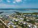 An aerial view of a beautiful canal-front home with private boat dock and lush landscaping at 9240 Pine Cove Dr, Englewood, FL 34224