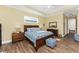 This primary bedroom boasts a decorative tray ceiling and a plush, blue floral bedding set at 9240 Pine Cove Dr, Englewood, FL 34224