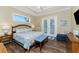 This primary bedroom has a light, beachy feel with a tray ceiling and access to the outdoor balcony at 9240 Pine Cove Dr, Englewood, FL 34224