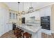 Modern kitchen with white cabinetry, granite countertops, stainless steel appliances, and an island with seating at 9240 Pine Cove Dr, Englewood, FL 34224