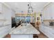 Spacious kitchen with granite countertops, a large island, and modern appliances overlooking a dining area at 9240 Pine Cove Dr, Englewood, FL 34224