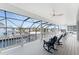 Spacious screened lanai with white railings, ceiling fans, and water view creates an ideal spot for relaxation at 9240 Pine Cove Dr, Englewood, FL 34224