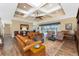 Comfortable living room featuring a coffered ceiling, wood floors, leather sofas, and a sliding door to the outdoors at 9240 Pine Cove Dr, Englewood, FL 34224