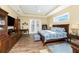 Serene main bedroom with tray ceilings, wood flooring, and access to an outdoor balcony at 9240 Pine Cove Dr, Englewood, FL 34224