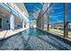 Long in-ground pool is showcased in a full, straight shot, partially enclosed with outdoor seating areas to the side at 9240 Pine Cove Dr, Englewood, FL 34224