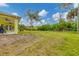 Spacious backyard with yellow house, trees and green foliage at 11247 Euler Ave, Englewood, FL 34224