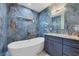 Bathroom with soaking tub, stylish blue marbled wall tiles and a vanity with granite countertop at 11247 Euler Ave, Englewood, FL 34224