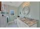 Bright bathroom with granite countertops, modern fixtures, and a glass-enclosed shower at 11247 Euler Ave, Englewood, FL 34224