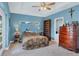 Comfortable bedroom with blue walls, natural light and a ceiling fan at 11247 Euler Ave, Englewood, FL 34224