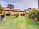 Spacious backyard with manicured lawn, tropical landscaping, and partial fence, perfect for outdoor enjoyment at 170 Antilla Dr, Rotonda West, FL 33947