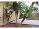 Paver driveway leading to a two-car garage surrounded by manicured landscaping with palm trees at 170 Antilla Dr, Rotonda West, FL 33947