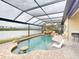 Inviting pool area featuring waterfall, rock features, and an adjacent lake view at 170 Antilla Dr, Rotonda West, FL 33947