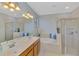 Bright bathroom with double sink vanity, separate shower, and large soaking tub at 20211 Granlago Dr, Venice, FL 34293