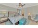 Spacious bedroom with comfortable seating area and view into a large bathroom at 20211 Granlago Dr, Venice, FL 34293