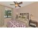 Cozy bedroom features a ceiling fan and a large bright window at 20211 Granlago Dr, Venice, FL 34293
