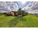 Landscaped backyard, with a glimpse of the outdoor, screened-in pool at 20211 Granlago Dr, Venice, FL 34293