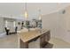 Kitchen island features a sink and seating and is open to the living and dining areas at 20211 Granlago Dr, Venice, FL 34293