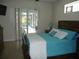 Cozy main bedroom with a queen bed, backyard views, and private access to the outdoor pool and patio at 380 Hoffer St, Port Charlotte, FL 33953