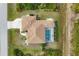 Aerial view of the home highlighting its screened pool, and surrounding landscape at 116 Hercules Dr, Rotonda West, FL 33947