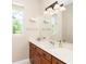 Bright bathroom features a large mirror, vanity with storage, and natural light from the window at 116 Hercules Dr, Rotonda West, FL 33947