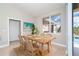 Inviting dining room with a wooden table set for four, a large window and sliding glass doors with a view of the pool at 116 Hercules Dr, Rotonda West, FL 33947