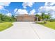 Charming single-story home featuring a three-car garage, mature palms, and a well-manicured lawn at 116 Hercules Dr, Rotonda West, FL 33947
