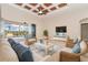 Bright living room features neutral tones, stylish ceiling fan, wicker furniture, and sliding door to a screened lanai at 116 Hercules Dr, Rotonda West, FL 33947